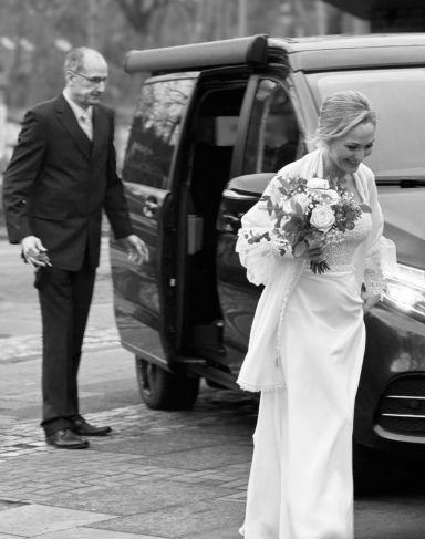 Braut steigt aus dem Hochzeitsauto