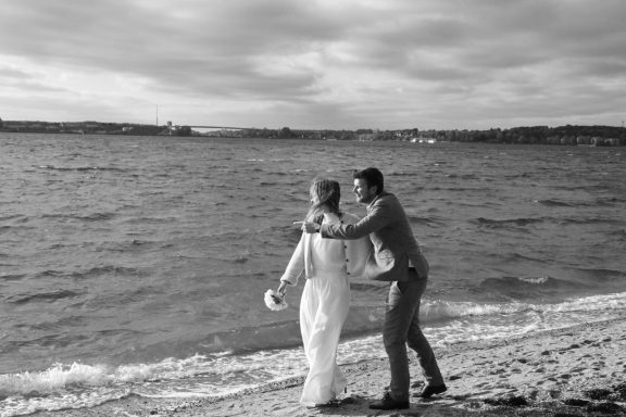 Braut mit ihrem Bräutigam beim Strandspaziergang.