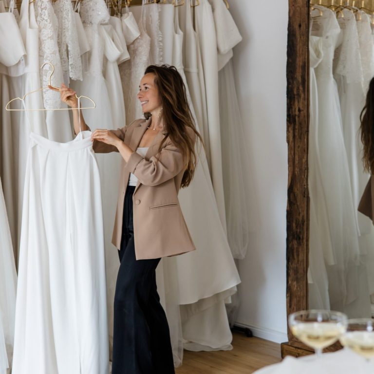 Egal ob Zweiteiler oder Brautkleid - Bei uns findest du besondere Brautmode. Ein Zweiteler als Brautmode wird hier am Bügel präsentiert. In Hintergrund sind weitere Brautkleidformen und Brautkleidstile zu erkennen.
