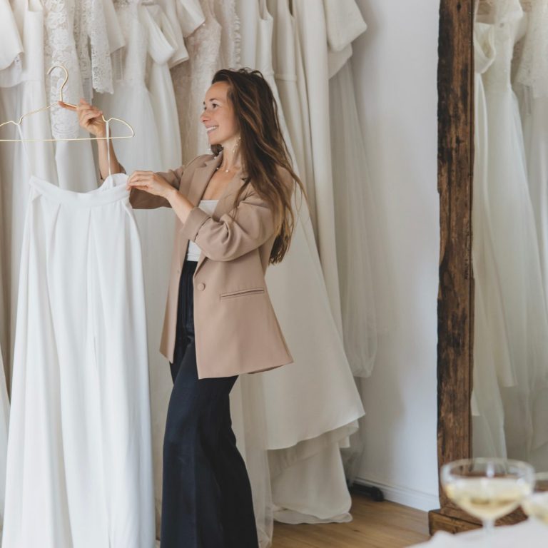 Ein Zweiteler als Brautmode wird hier am Bügel präsentiert. In Hintergrund sind weitere Brautkleidformen und Brautkleidstile zu erkennen.