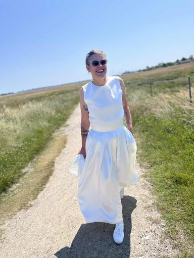 Braut auf einem Feld im lässigen Zweiteiler.