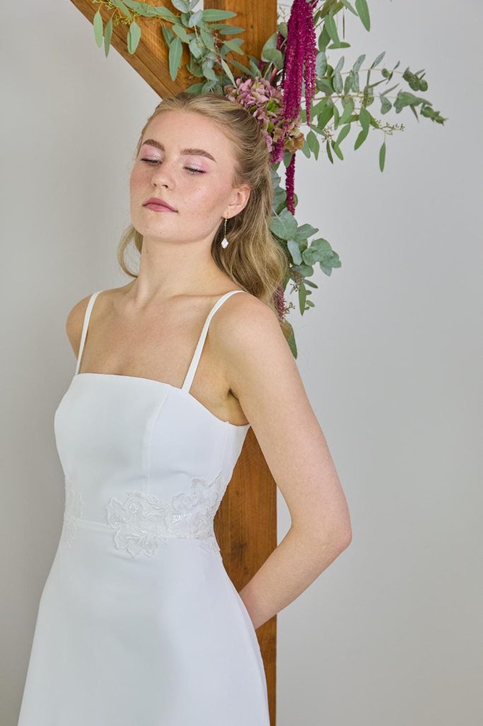 LEEVÉ Handgefertigtes Brautkleid aus Kiel mit kleinen Spitzendetails.