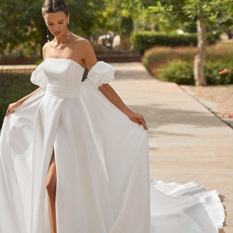 Brautkleid A-Linie mit tiefem V-Ausschnitt und Spitze. Das Hochzeitskleid mit Beinschlitz. Brautmode in Kiel.