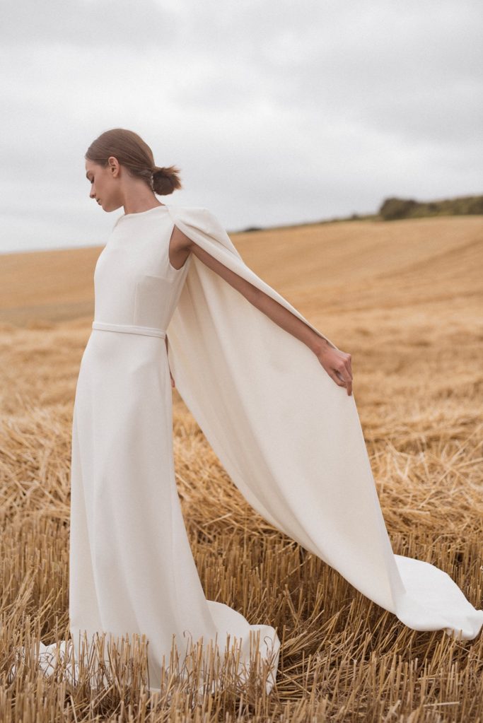 Clean Bridal Look. Kleid aus Stretch-Crepe mit Cape. Für die außergewöhnliche Braut.
