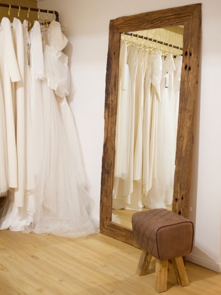 Ein großer Spiegel in einem Holzrahmen schmückt das Brautgeschäft in Kiel.